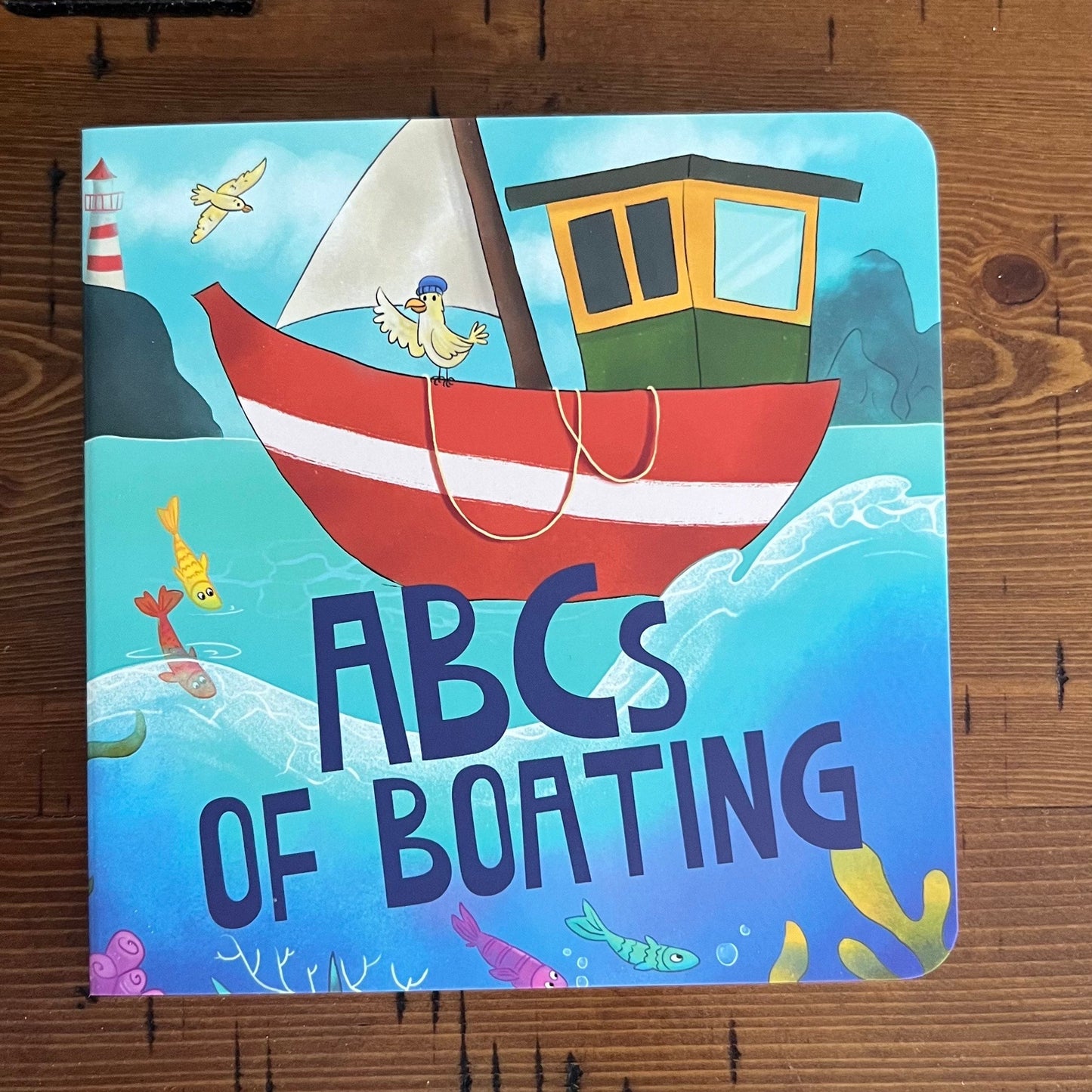 Children's book titled 'ABCs of Boating' on a wooden surface